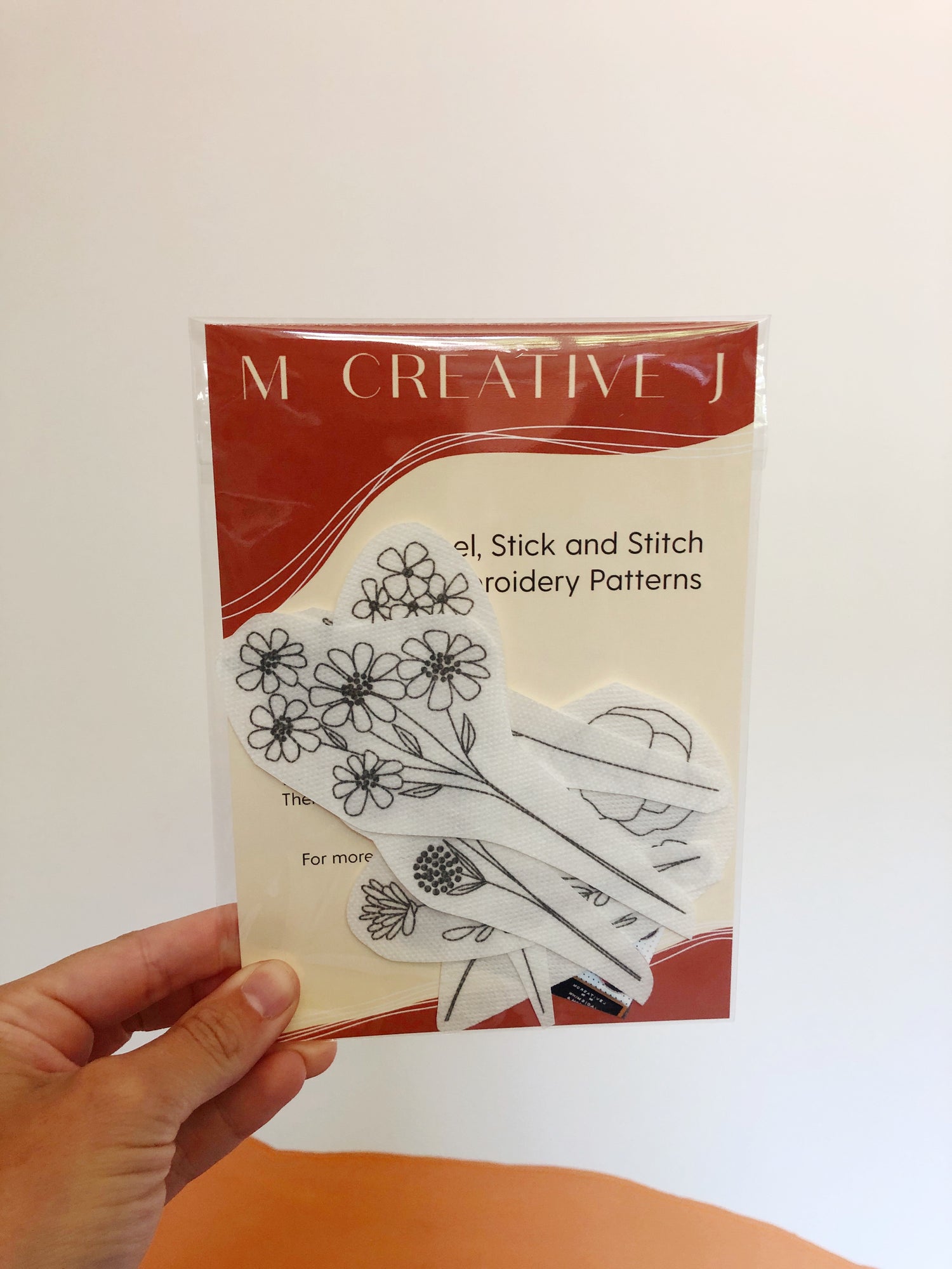 Small plastic bag containing the peel and stick and stick patterns for the Wildflower Stems Stick and Stitch Embroidery Pattern Kit