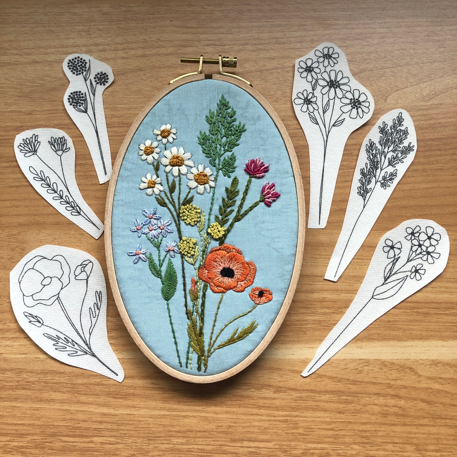 Completed design using wildflower stems stick and stitch embroidery pattern kit. Includes the 6 peel, stick, and stick designs around the completed project.