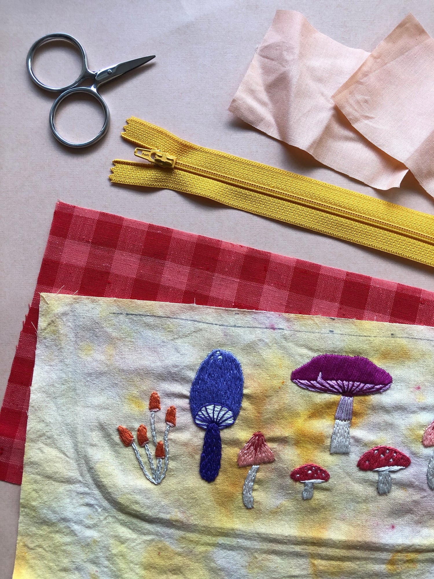 Example of Mushroom Stick and Stitch Embroidery Patterns Embroidered on Fabric With Materials in Background