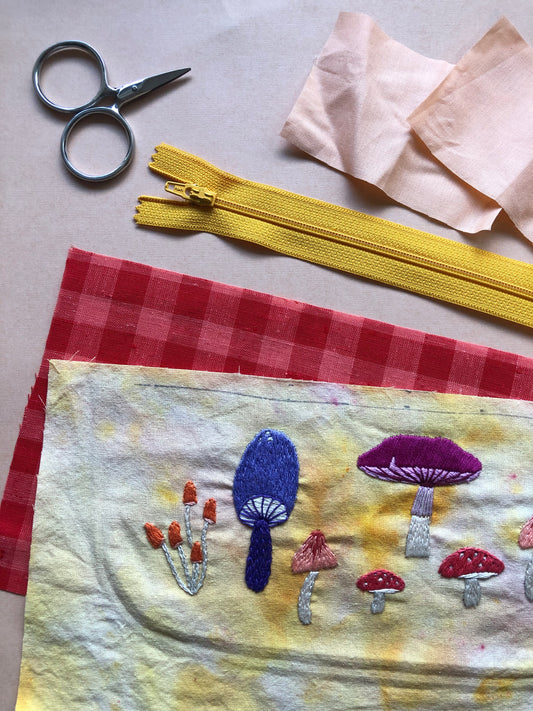Example of Mushroom Stick and Stitch Embroidery Patterns Embroidered on Fabric With Materials in Background